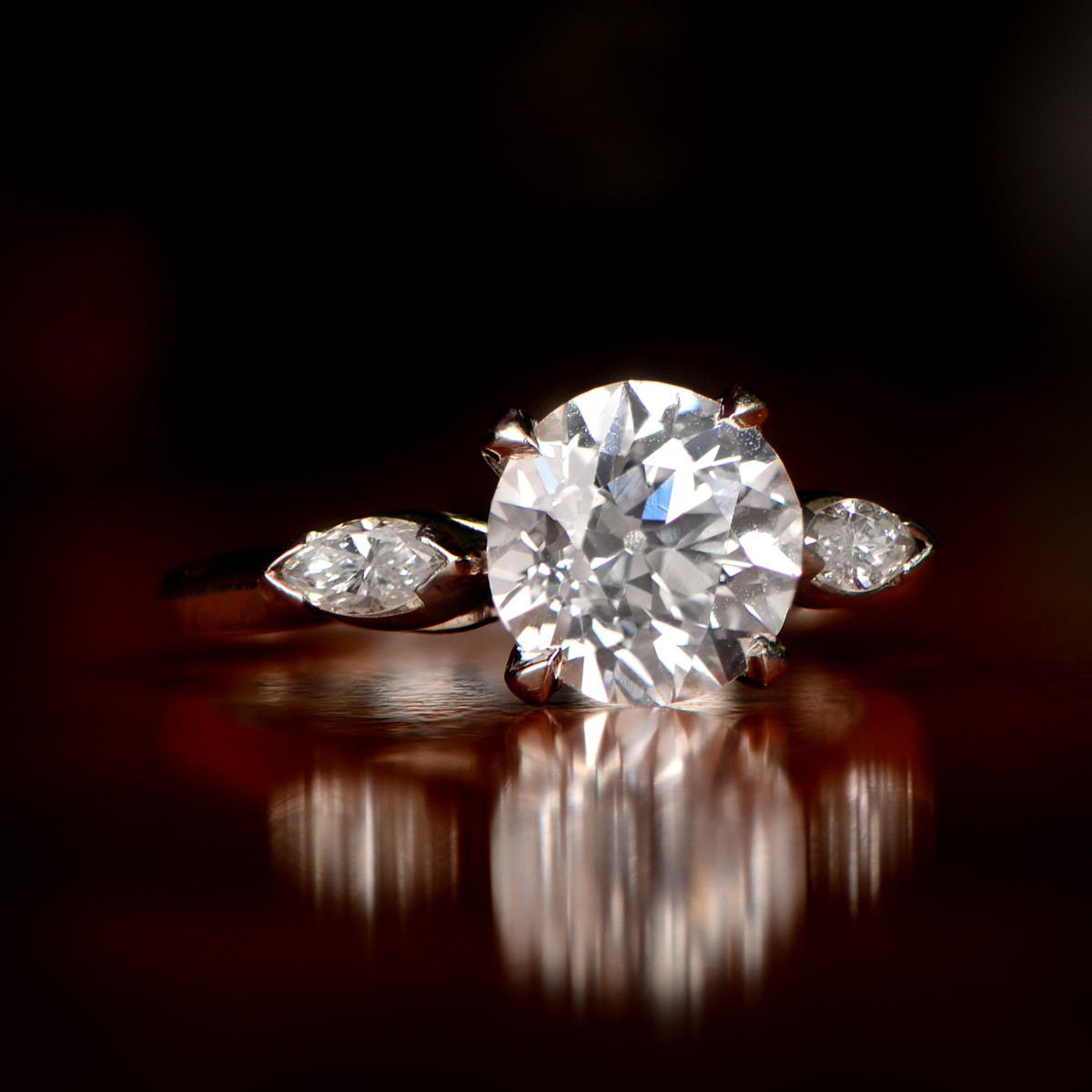 A vintage platinum diamond ring photographed against a dark background